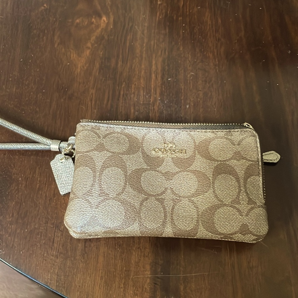Medium Coach wristlet. Good condition, no scratches,dark stain on one corner